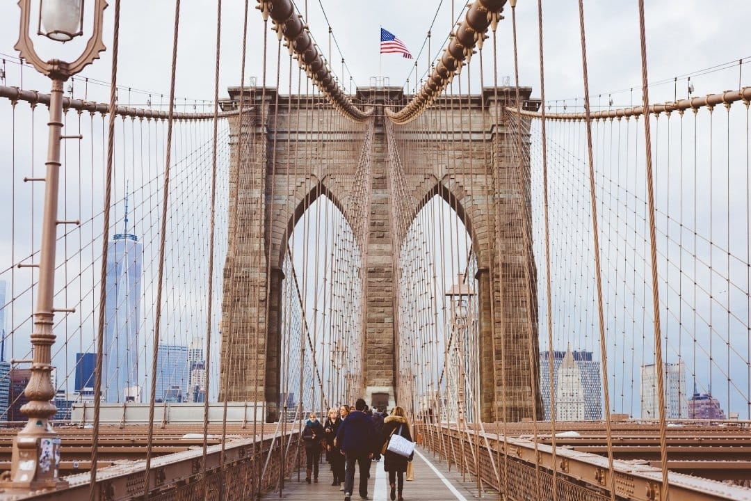 people-walking-brooklyn-bridge-american-flag.jpg