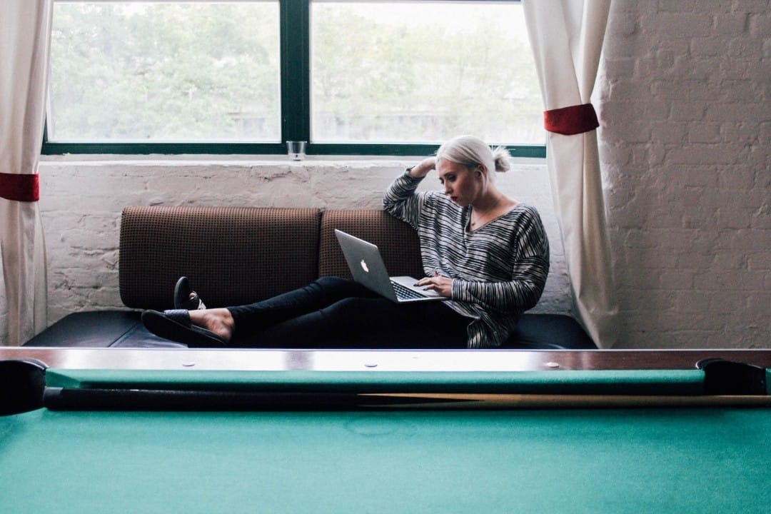 woman-sitting-with-laptop-behind-pool-table.jpg